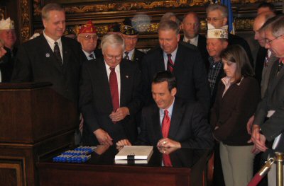 Governor Pawlenty shares a laugh with veterans and legislators after signing S.F. 3683, the Omnibus ...